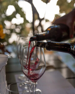 Red wine being poured into two glasses