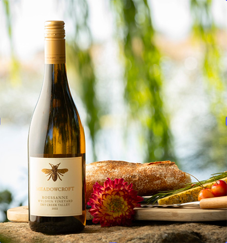 Bottle of Meadowcroft wine with an assortment of food